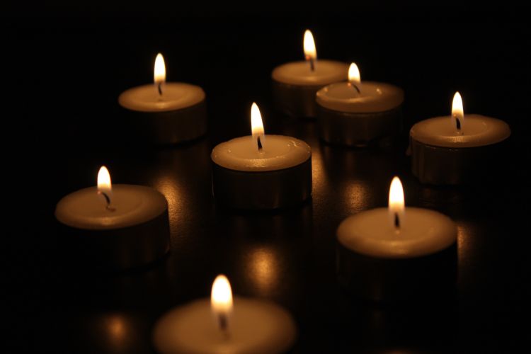 Lit votive candles with a dark background