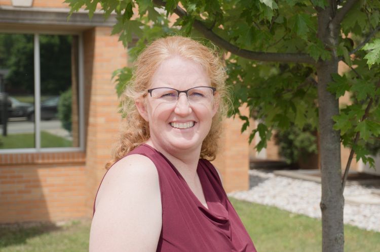 A headshot of Michelle Neff wearing a maroon blouse.