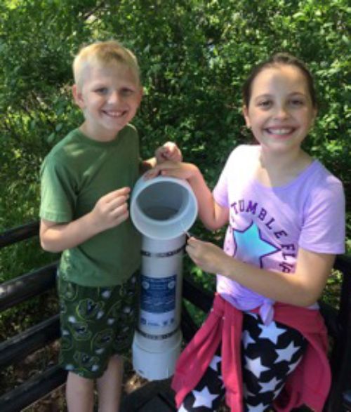 Alpena Elementary School students show off their completed monofilament recycling station – one of two installed on Rotary Island. Photo: Tina DenBleyker. Below: DenBleyker and students review debris they picked up at the island.