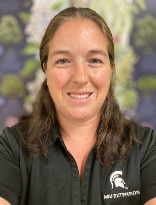 A headshot of Danielle Schrock, smiling and wearing a green polo with the MSU Extension logo on it.