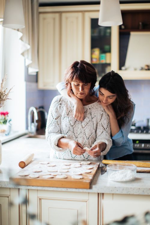 Parent and teenager baking together in kitchen.