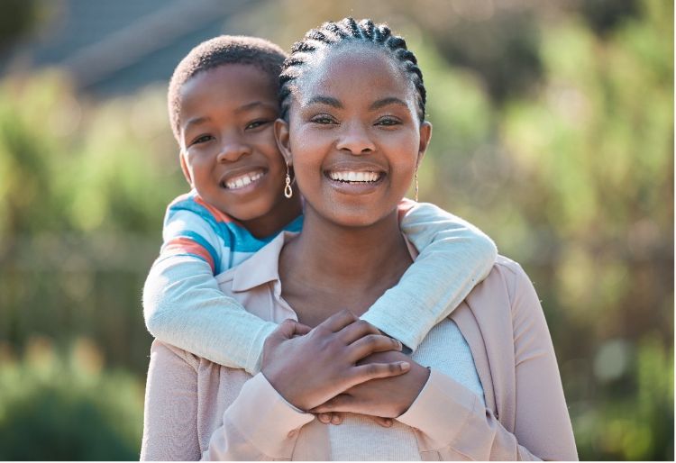 child hugging mother, mother and child are both smiling