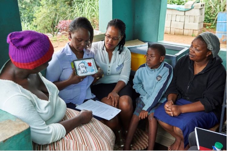 Girl showing people around her a picture