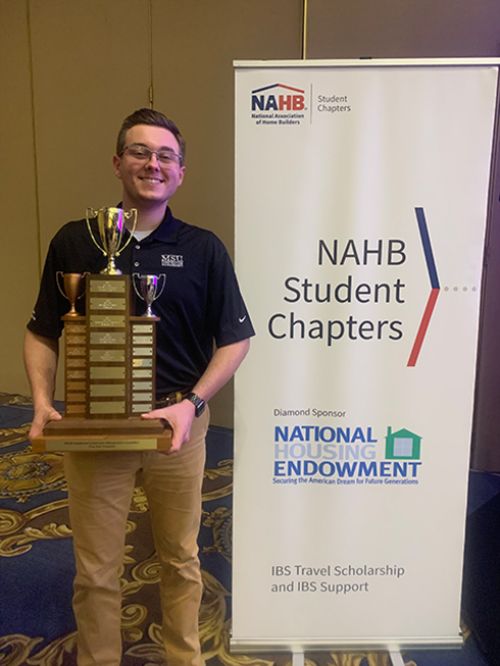 Alex Beem proudly stands with his award.