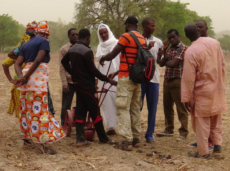 African smallholder farmers discuss a planter that was created by local blacksmiths with the help of MSU scientist Tim Harrigan.