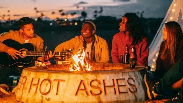 People gathered around a fire outdoors.