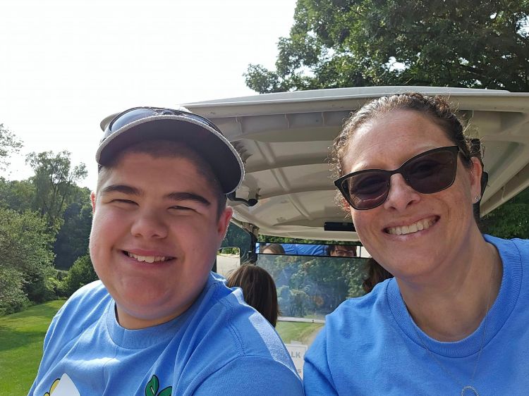 A volunteer and a youth smiling.