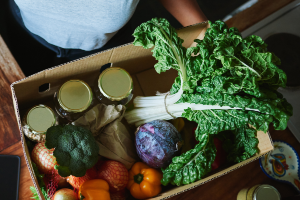 Box of fresh produce and canned goods