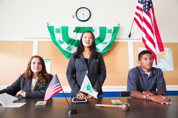 Three youth officers leading a club meeting.