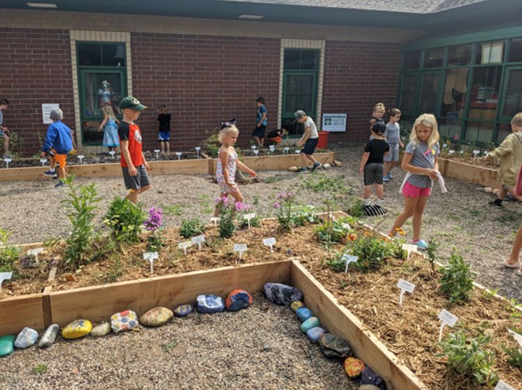 Children walking through a garden.