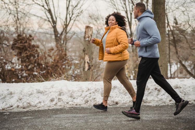 Two people walking outdoors in wintertime.