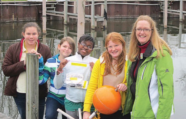 Harper Woods Middle School teacher June Teisan (right) and students deploy a Basic Information Float on Lake St. Clair in St. Clair Shores. Photo credit: June Teisan