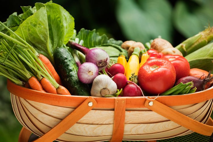 Various produce in a wooden basket.