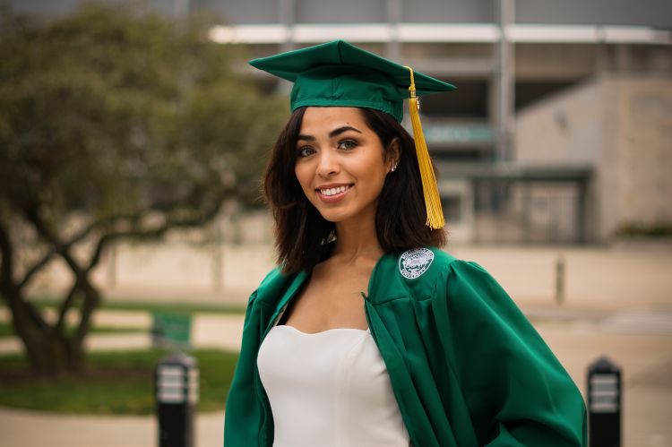 Ashley Prince in her cap and gown on the campus of Michigan State University.