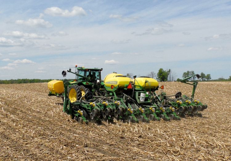 A tractor planting no-till soybeans in a soybean field.