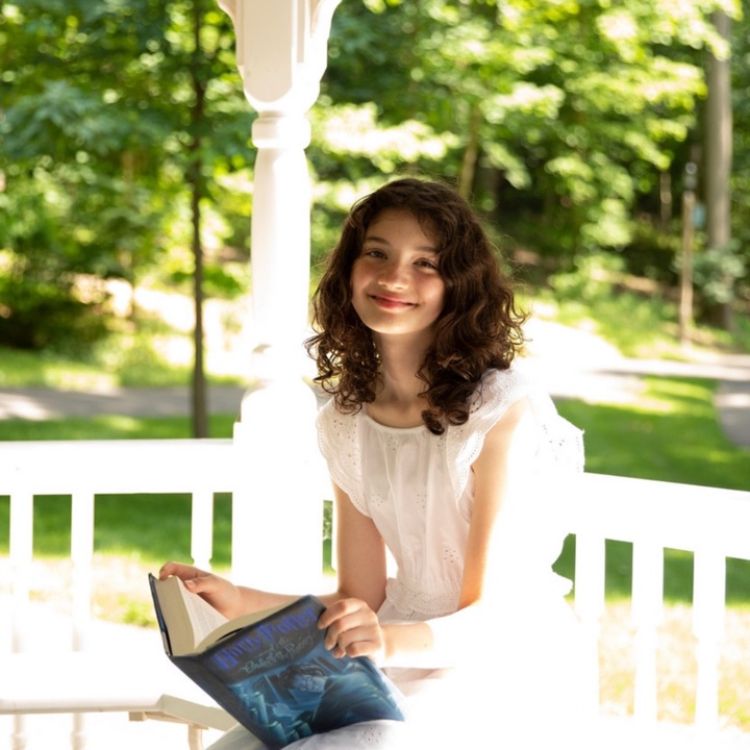 Photo of a girl holding a Harry Potter book.