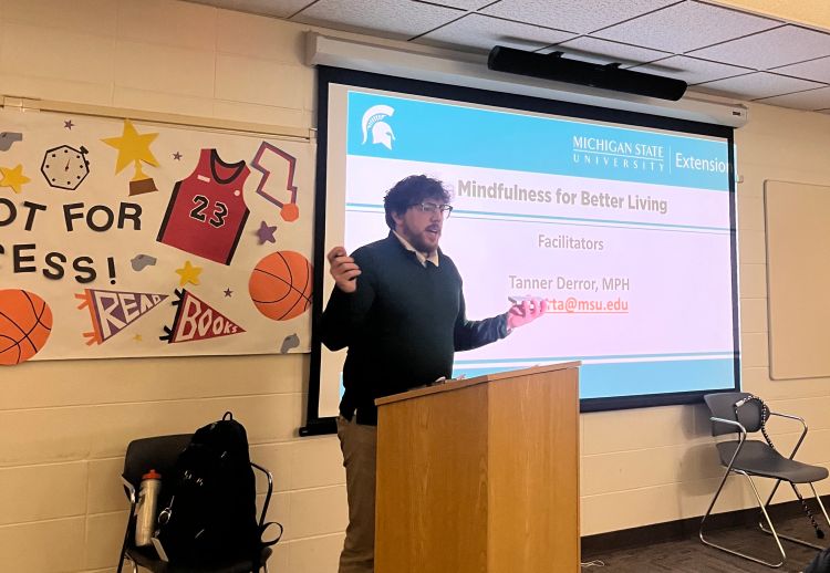 An MSU Extension Health Educator, Tanner Derror presents on mindfulness at a local library.