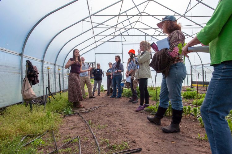 Farmers gather together in a hoophouse during a farmer training session