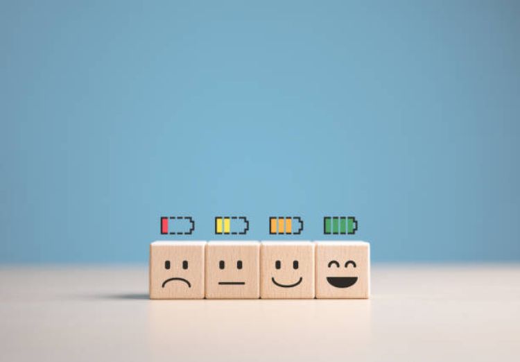 Four dice with four faces on them, ranging from sad to happy. Above each face is a battery icon indicating the corresponding battery life, ranging from low (red) to full (green).