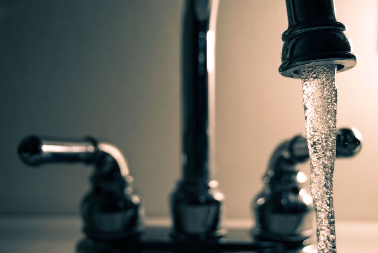 A photo of water running out of a kitchen sink.