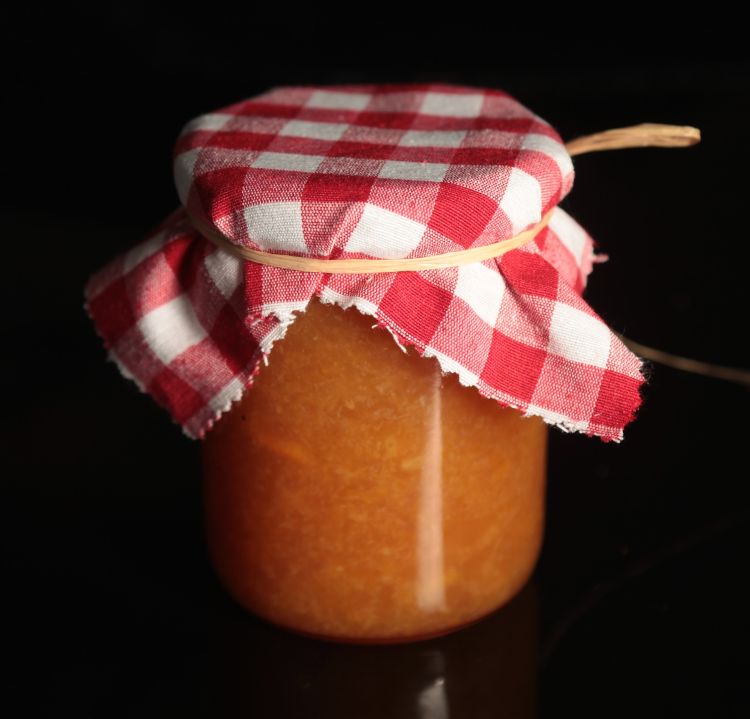 Jar of homemade jam with cloth tied over the lid.