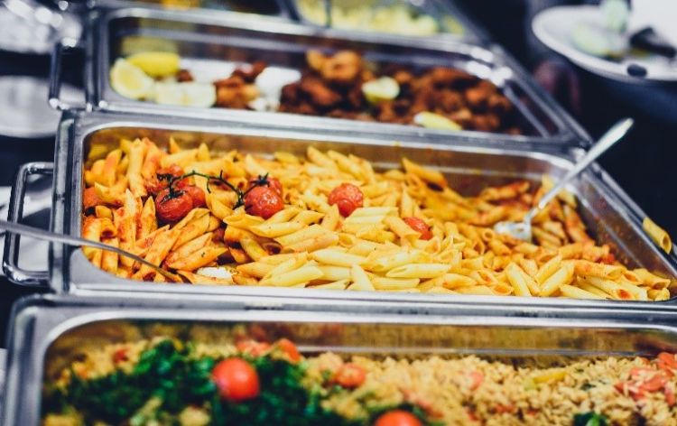 Various food items in a buffet line.