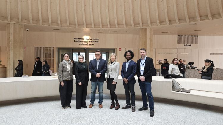 Michigan delegation, attending the multi-state wood building trade and study mission, posing for a picture inside a wooden building.