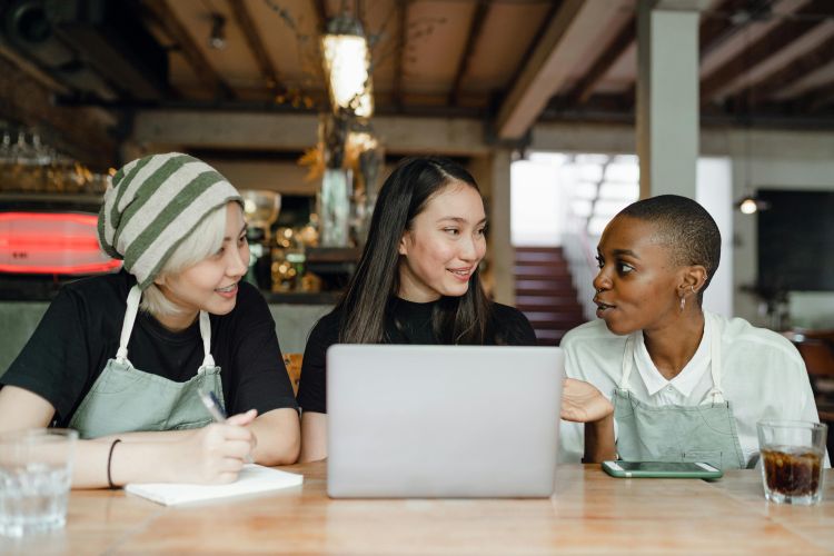 Three diverse individuals sitting at a table.