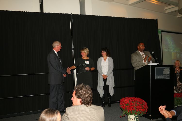 MSU Extension Director Jeff Dwyer presents Julie Metty Bennett and Lisa Marckini-Polk with a Key Partner Award during Fall Extension Conference. Photo: Justin Selden | Michigan Sea Grant