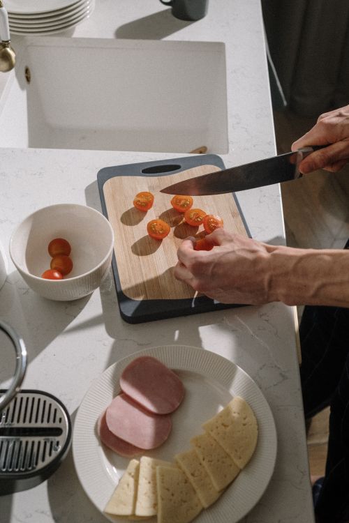 A closeup of someone chopping vegetables for a lunch platter.