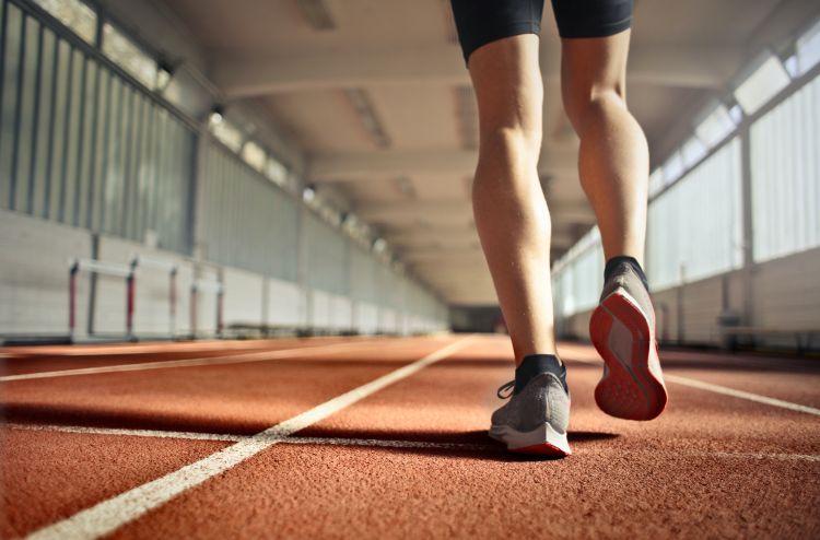 A close up of someone's shoes as they walk on a track.