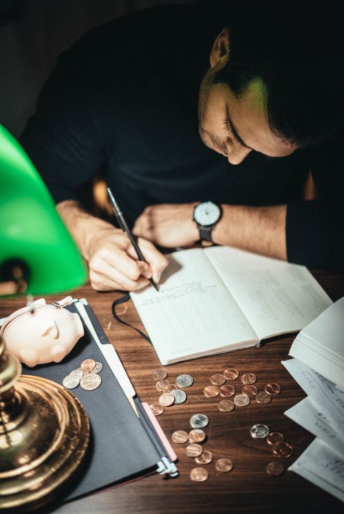 Man writing down his finances in a book.