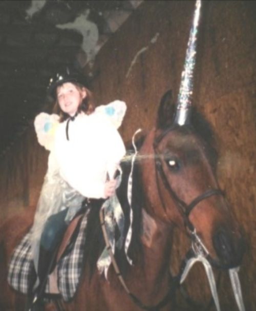 A girl on a horse dressed as a unicorn