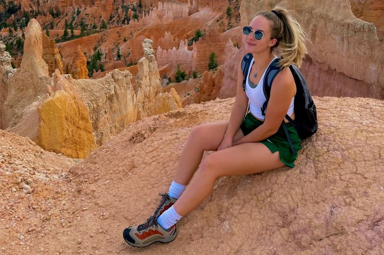 A woman poses for a photo while on a hike in the mountains.