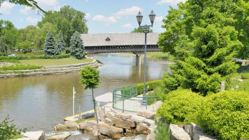 Photo of a river and a covered bridge.