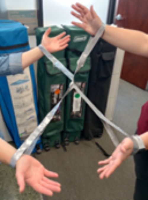 Two youth in duct tape handcuffs.