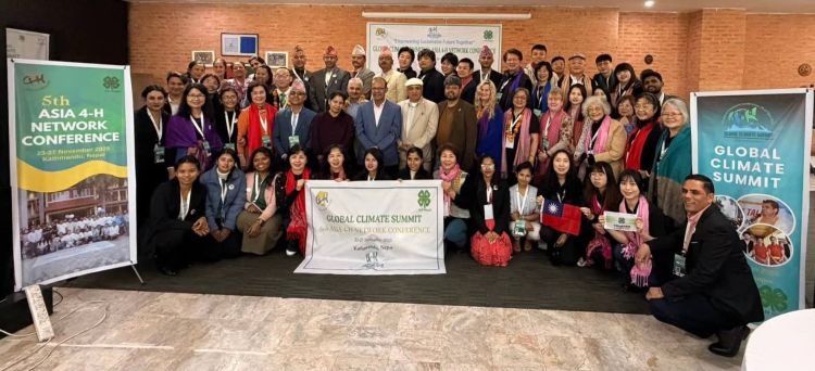 A large group of people with signs that say Global Climate Summit and 5th Asia 4-H Network Conference.