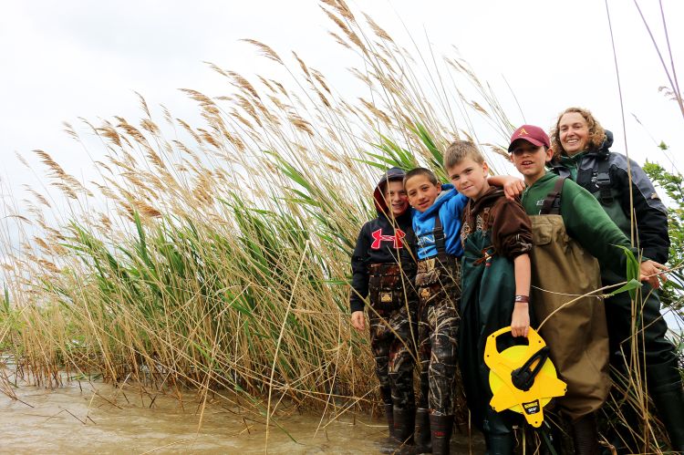 MSU Extension educator Tracy D’Augustino with fifth graders from Au-Gres-Sims standing in front of the phragmites on Charity Island.