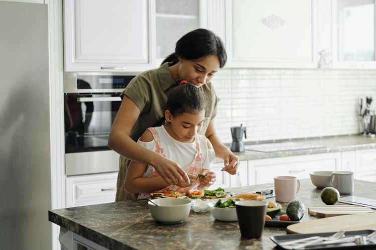 A mother and daughter cooking together.