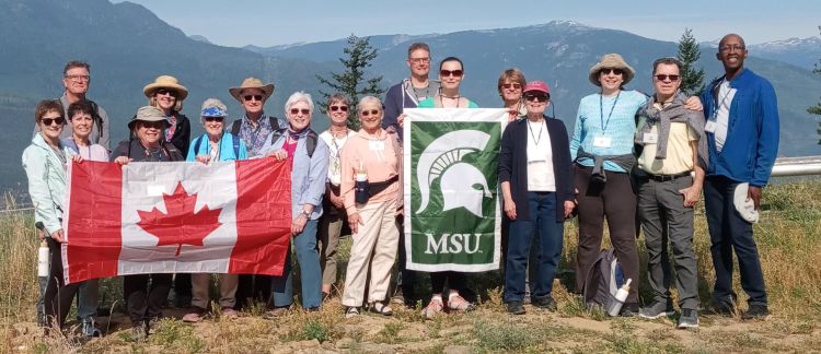 A group of people holding the Canadian flag as well as an MSU flag.