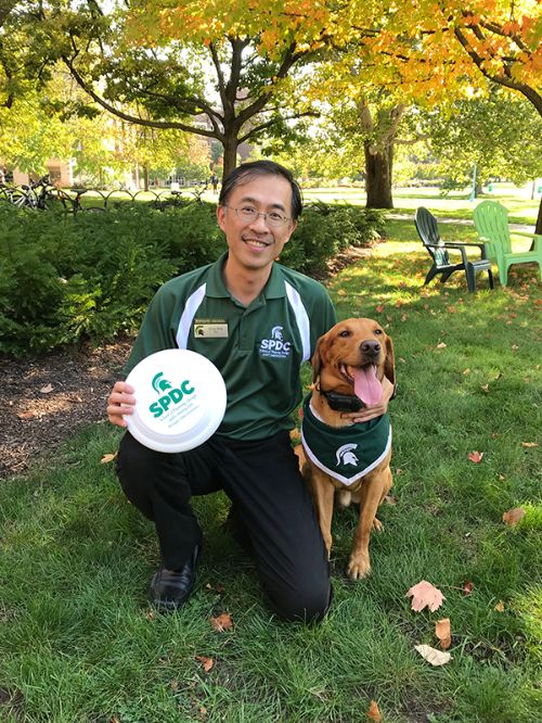 Photo of Ming-Han Li, director of the School of Planning, Design and Construction with Zeke the Wonderdog.