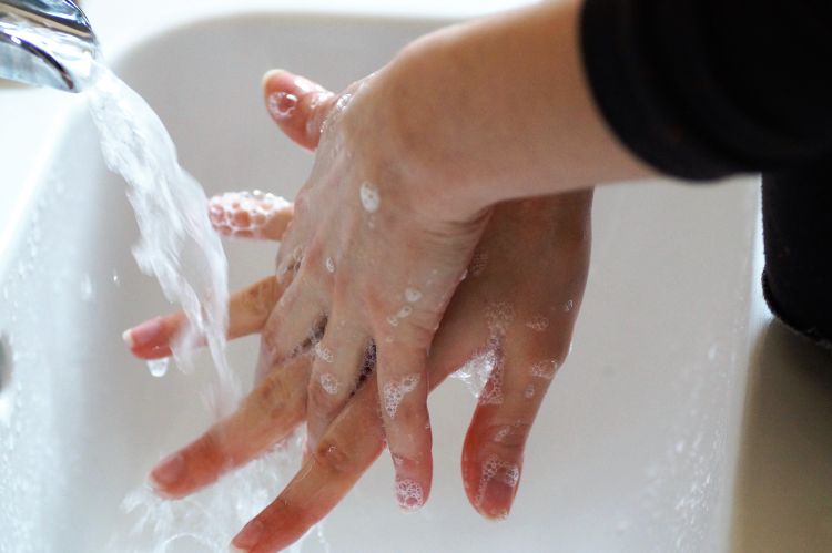 A photo of a person washing their hands with soap.