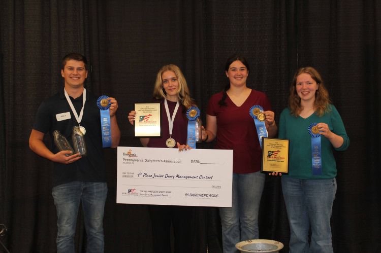 Four individuals holding up ribbons.