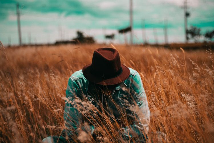 A guy kneeling in a field