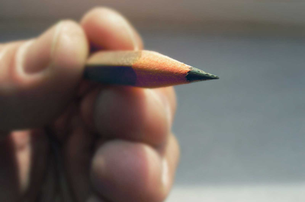 Person holding pencil up-close view