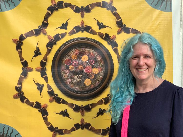 Jennifer Angus photographed next to her art, insects arranged into an intricate mandala.