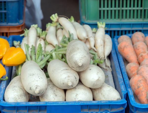 Peppers, turnips, and carrots in bulk bins.
