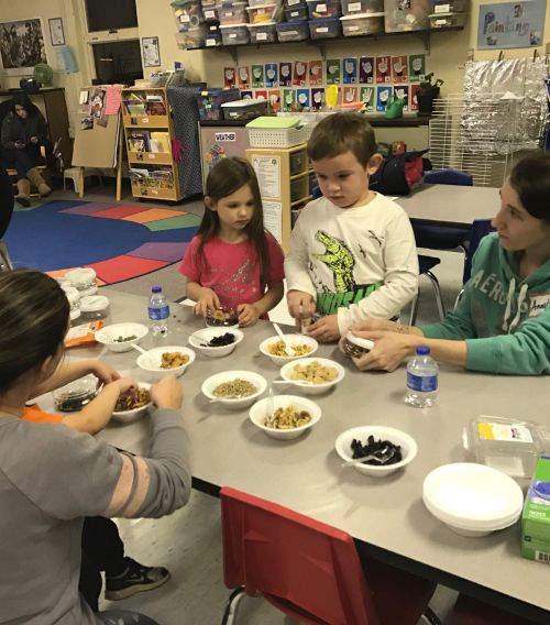 Kids with bowls of vegetables.