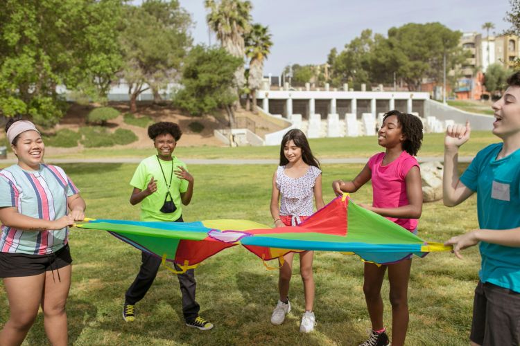 Diverse group of children playing together outside.