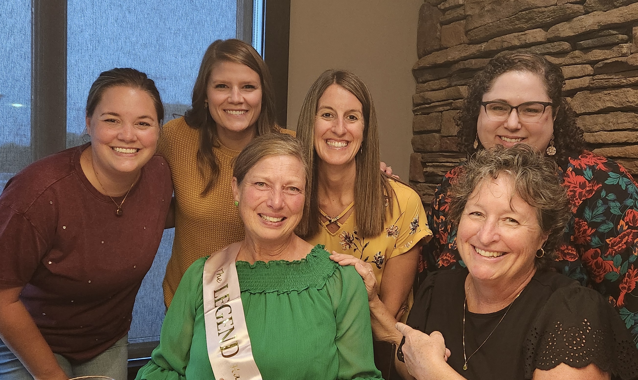 A photo of Becky Henne with current and former staff.